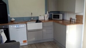 A compact kitchen with a microwave, toaster, and sink. - Chalet Retreat in Mablethorpe (Mablethorpe)