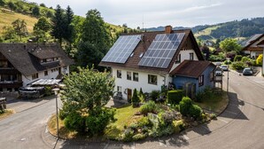 Uma área residencial com casas, painéis solares e uma estrada.
