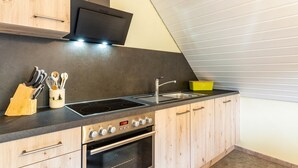 Uma cozinha com fogão, forno, pia e armários de madeira.