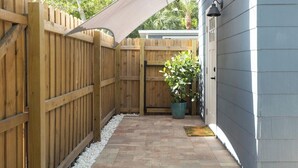 Une clôture en bois, un pot de fleurs et une maison à l’extérieur gris.