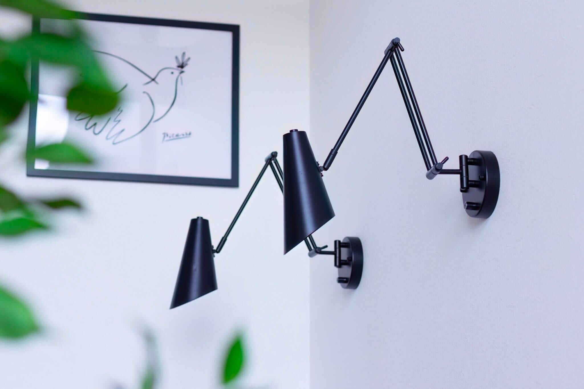 Une lampe de bureau à fixer au mur, dotée de trois bras réglables.