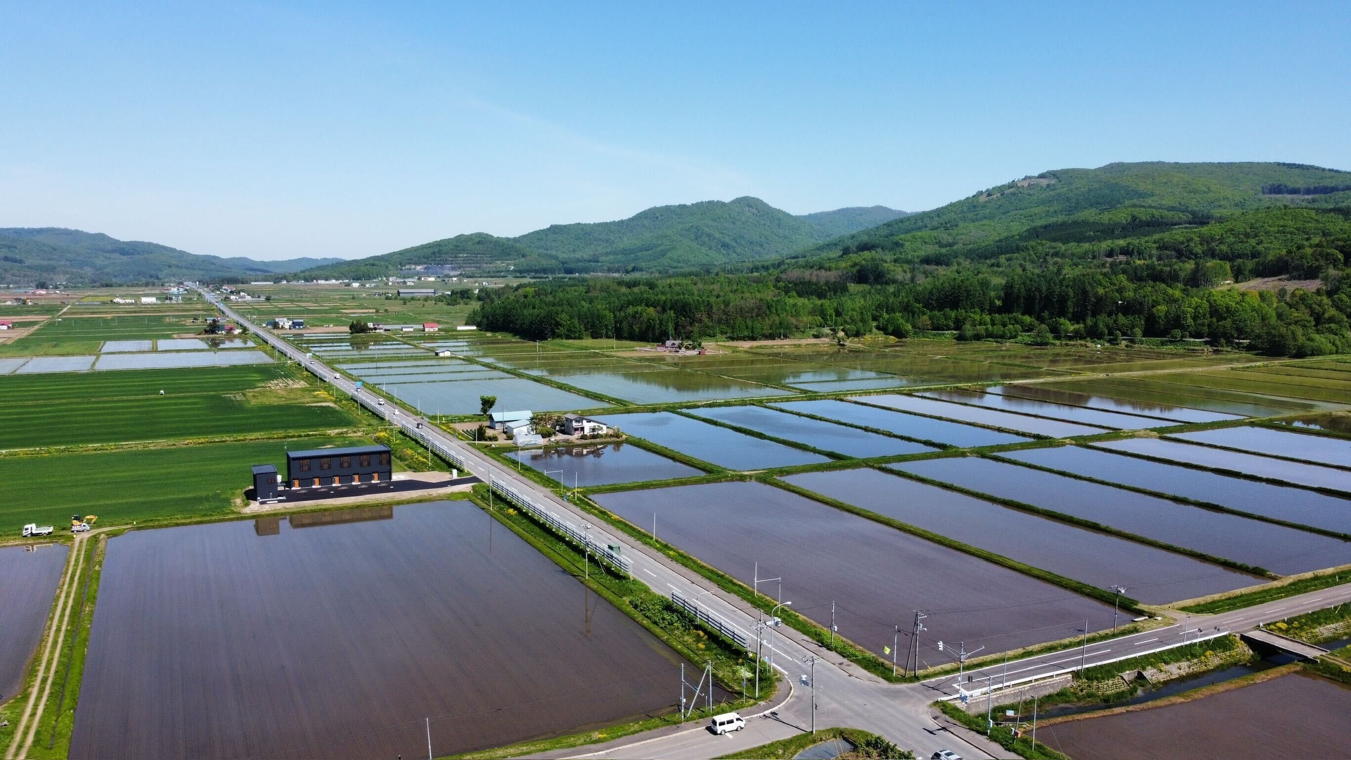 An aerial view of a large agricultural area with multiple water bodies and a road running through it.
