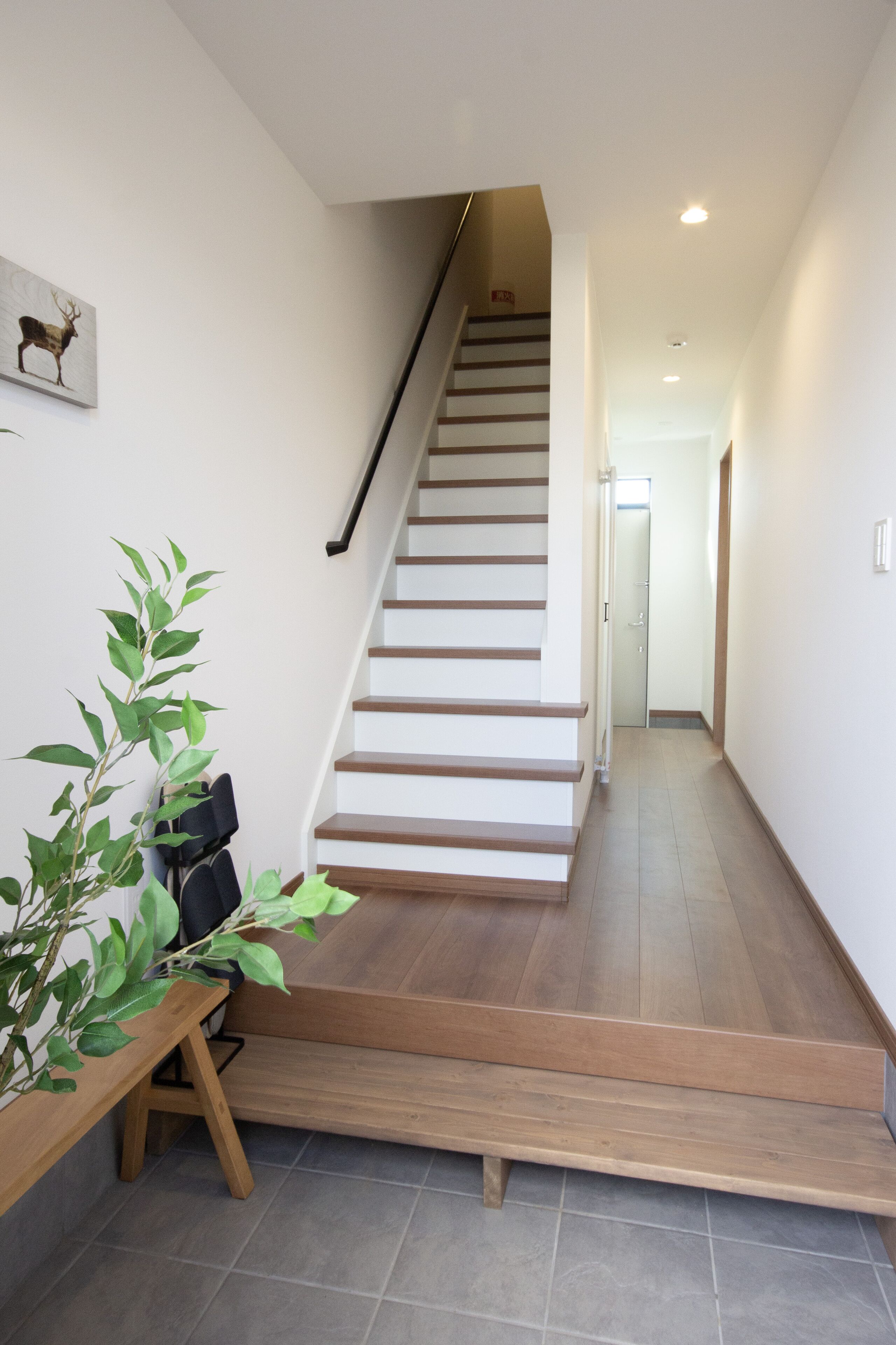 Una escalera de madera con barandilla, que conduce a una puerta en la parte superior.