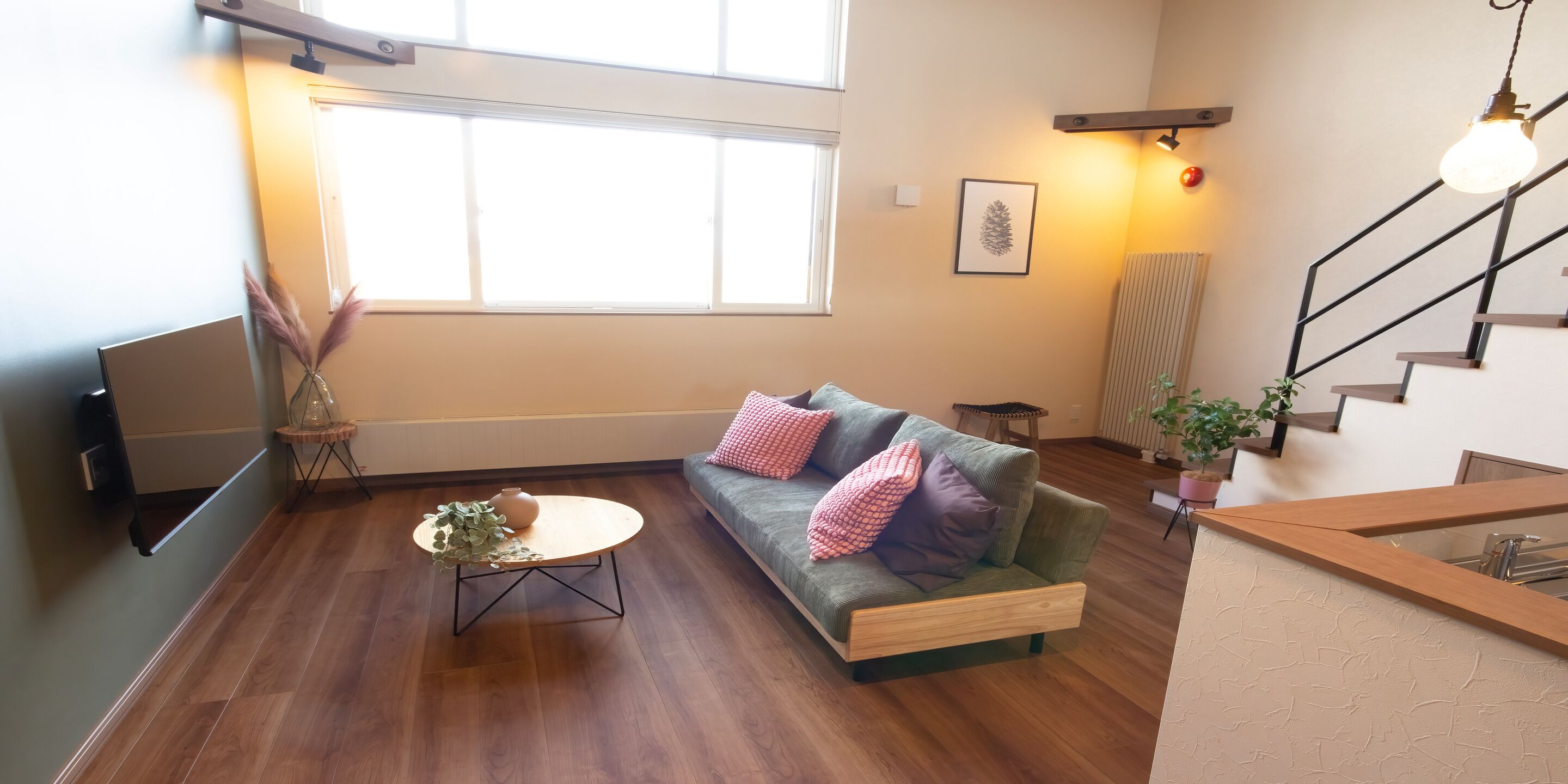 A modern living room with a sofa, a coffee table, and a staircase.