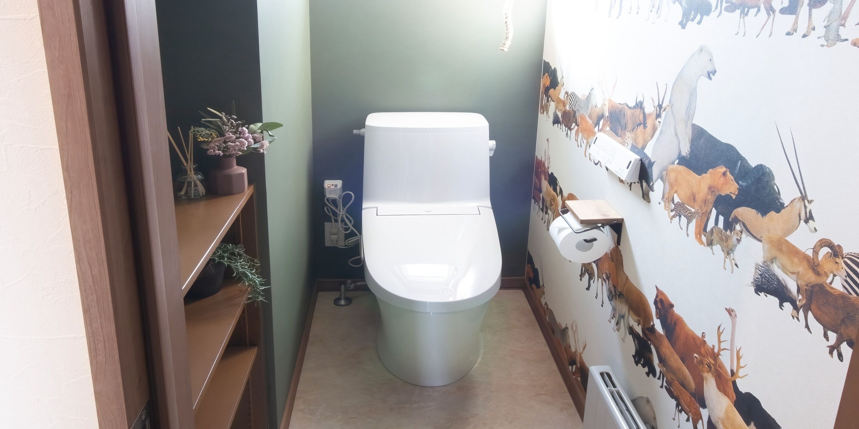 A bathroom with a toilet, a wall-mounted toilet paper holder, a radiator, and a shelf with plants.