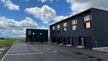 A modern building with a parking lot and a clear sky.