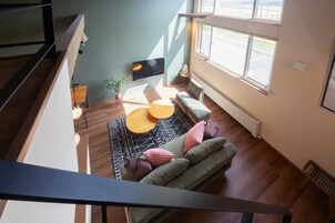 A modern living room with a sofa, a coffee table, and a TV mounted on the wall.