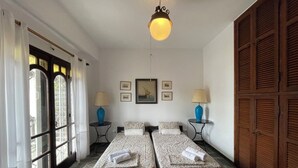 A room with two beds, a wooden wardrobe, a ceiling light, and a window with curtains. - Spacious Maisonette on the "eu Blue Beach" of Kalogria in Sithonia in Greece (Sithonia)