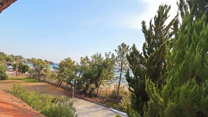 A coastal property with a tiled roof, a stone pathway, and a view of the sea. - Spacious Maisonette on the "eu Blue Beach" of Kalogria in Sithonia in Greece (Sithonia)
