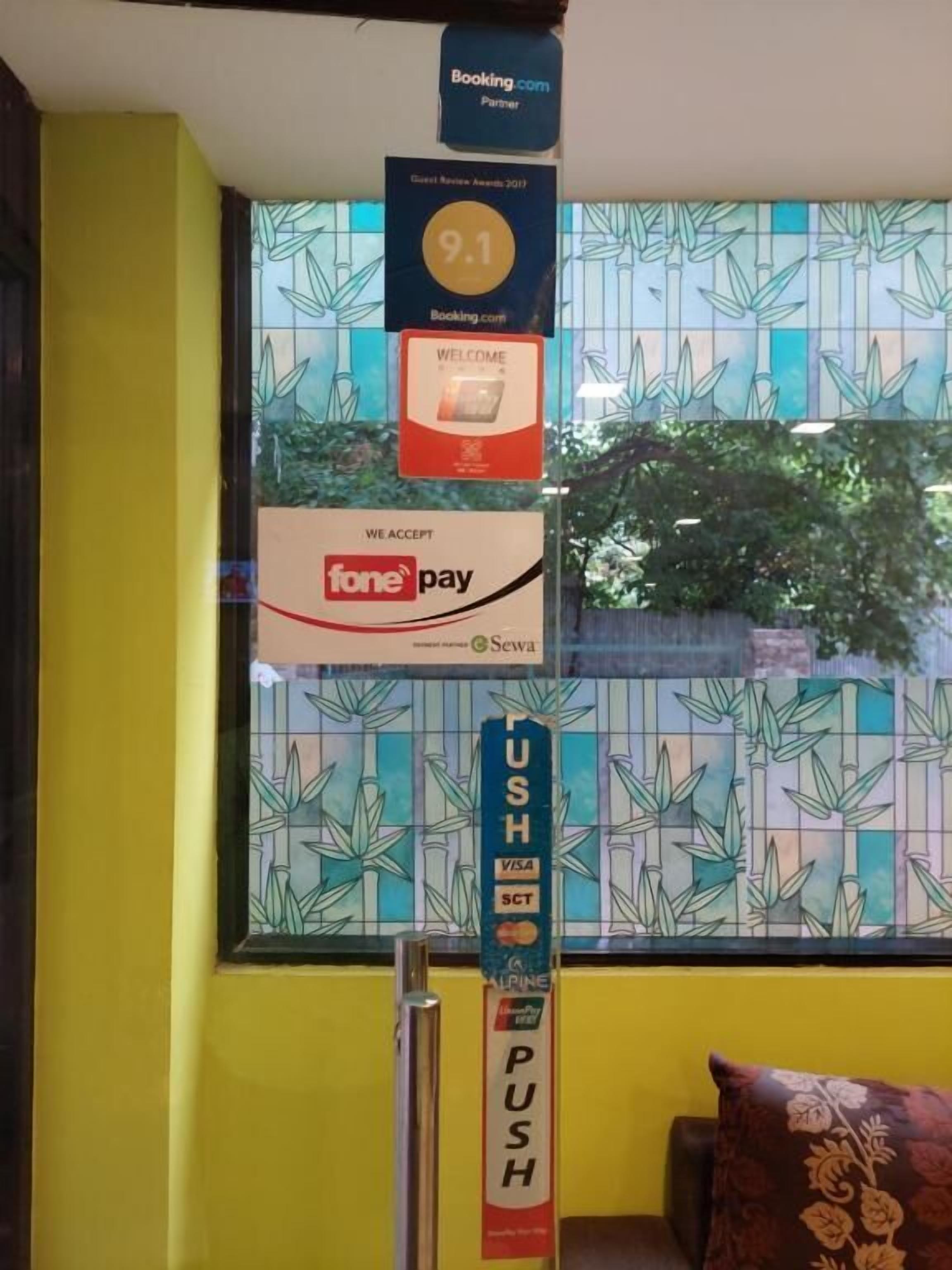 A wall with a bamboo pattern and a window with a view of greenery.
