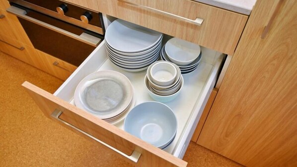 A kitchen drawer with neatly stacked plates and bowls.