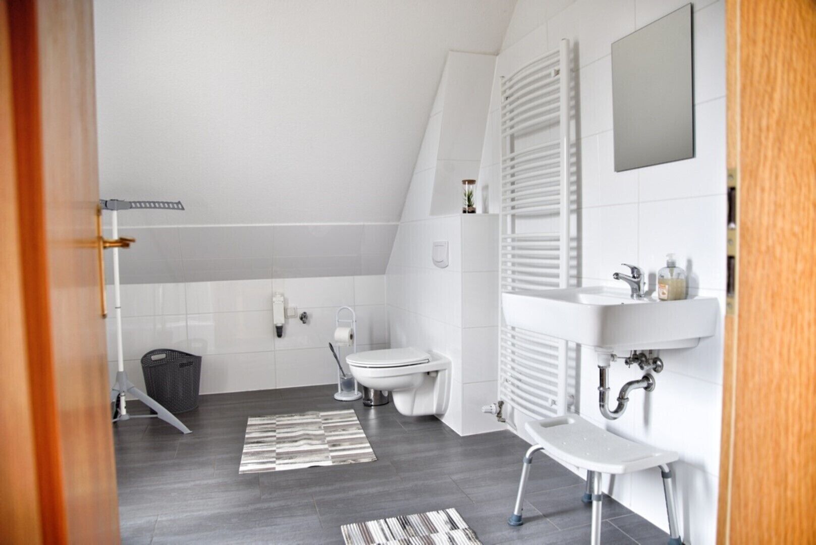 Un baño moderno con inodoro, lavamanos y ducha.