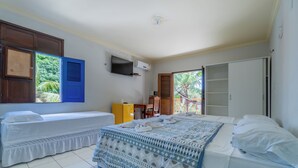 Une chambre avec deux lits simples, une télévision et une armoire.