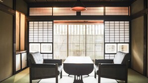 A traditional Japanese room with tatami flooring, a low table, two chairs, and shoji screens. - Nipponia Izumo Taisha Shrine Town (Izumo)