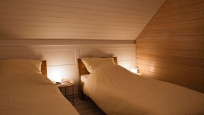 A small, cozy room with two single beds, a small table, and a lamp. - The Perfect House to Stay for Holidays (Oberharz am Brocken)