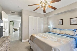 A bedroom with a bed, a ceiling fan, a wardrobe, and a door leading to another room. - Newly Listed Sea Forever Cottage | Flagler Beach | Across From The Beach | Dog Friendly (Beverly Beach)