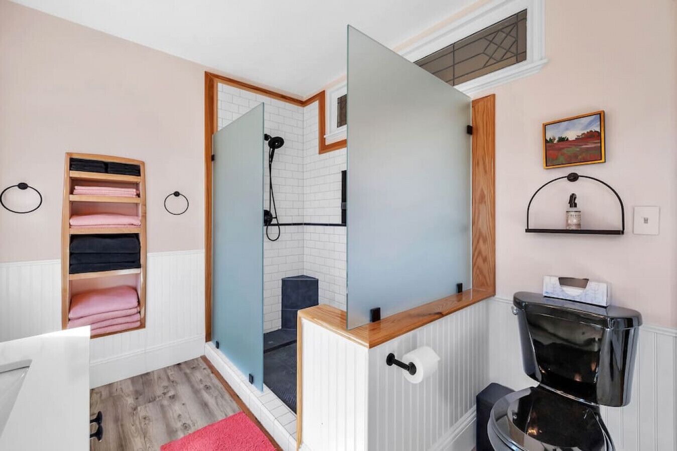 Un baño con ducha, inodoro, lavabo, toallero y espejo.