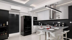 A modern kitchen with a central island, bar stools, and a built-in microwave. - Rhodes Skyline Suite With out Door Jacuzzi Sea View A1 (Rhodes)