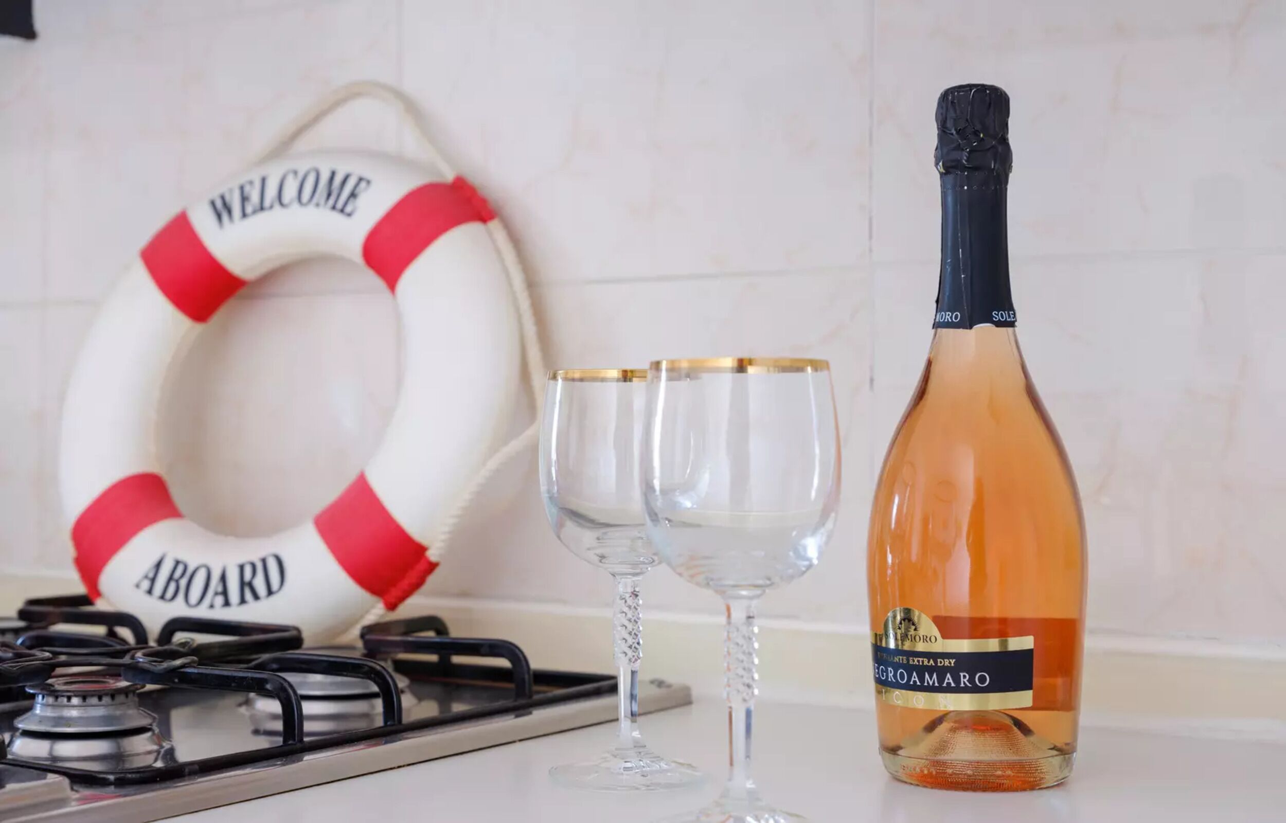 A bottle of wine, two glasses, a life preserver, and a stove.