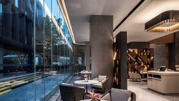 A modern hotel lobby with glass walls, seating areas, and a reception desk. - UrCove by Hyatt Shanghai Lujiazui EXPO (Shanghai)