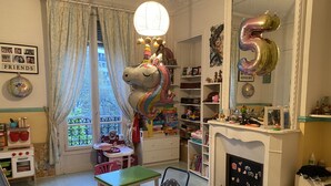 A child's playroom with a toy table, chairs, a bookshelf, and a fireplace. - Champs Élysées (Paris)