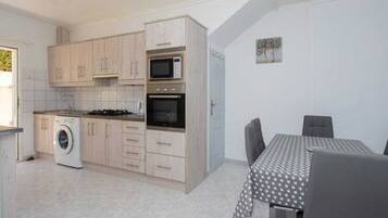 Een koelkast, een magnetron, een oven, eettafels