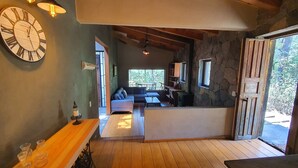 Um interior acolhedor com uma mesa de jantar de madeira, um sofá e uma parede de pedra.