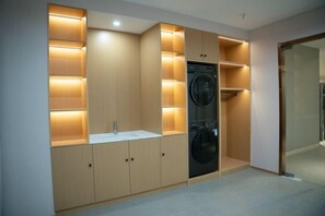 Una cuina moderna amb electrodomèstics integrats, incloent-hi una rentadora i un rentaplat.