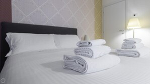 A neatly made bed with white linens and two stacks of folded towels. - Italianway Collection - Corso Como 11 - C (Milan)