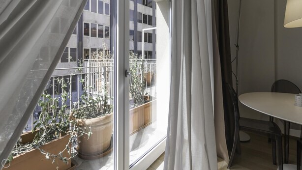 A balcony with potted plants, a dining table, and a chair. - Italianway Collection - Corso Como 11 - C (Milan)
