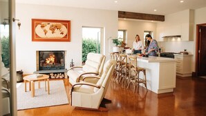 Una cocina moderna con una isla central, una zona de comedor con sillas, una chimenea y un gran mapa mundial en la pared.