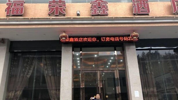 A hotel entrance with large glass doors and a sign above that reads "福荣鑫酒店". - Fenggang Furongxin Hotel (Fenggang)
