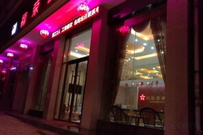 Une façade d’immeuble avec une enseigne lumineuse et une grande fenêtre en verre.