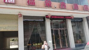 A hotel entrance with a signboard and a person standing in front. - Fenggang Furongxin Hotel (Fenggang)