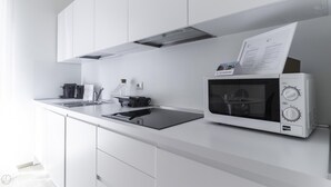 A modern kitchen with white cabinets, a built-in microwave, and a coffee machine. - Italianway Collection - Corso Como 11 - D (Milan)