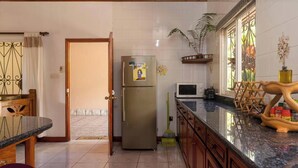 A kitchen with a refrigerator, microwave, and wooden cabinet. - Effi Mountain View Colibri Villa (Mahé Island)