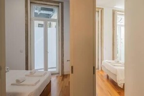 Una habitación de hotel con una cama, una mesita y un ventanal.