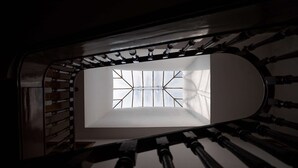Eine Wendeltreppe mit Oberlicht, das zu einem Raum führt.
