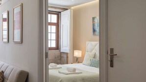 Ein Hotelzimmer mit einem Bett, einem Nachttisch, einer Lampe und einem Gemälde an der Wand.