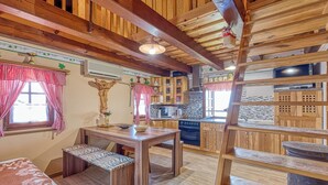 A wooden interior with a dining area, kitchen, and a staircase. - Vineyard Cottage Vesna Lake View (Cirkulane)