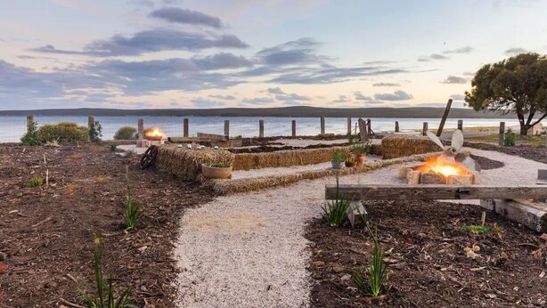 A garden with a fire pit, a gravel path, and a view of the water. - The Loft at Tulka House. The Seafood capital of South Australia. (Tulka)