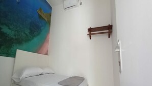 A bedroom with a bed, white walls, a ceiling mural, and a small wooden shelf. - OYO 90974 Homestay Golo Koe Sejahtera (Labuan Bajo)