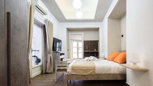 A bedroom with a bed, a desk, a chair, a television, and a skylight. - Piazza Nicola Amore 14 (Naples)