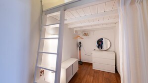 A bedroom with a loft bed, a dresser, a mirror, and a vacuum cleaner. - La Pietra al Pigneto (Rome)