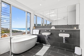 Bathtub, hair dryer, towels, toilet paper