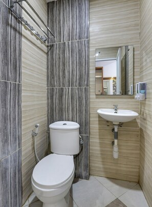 Habitación estándar con 2 camas individuales | Baño | Regadera, regadera tipo lluvia, papel de baño 