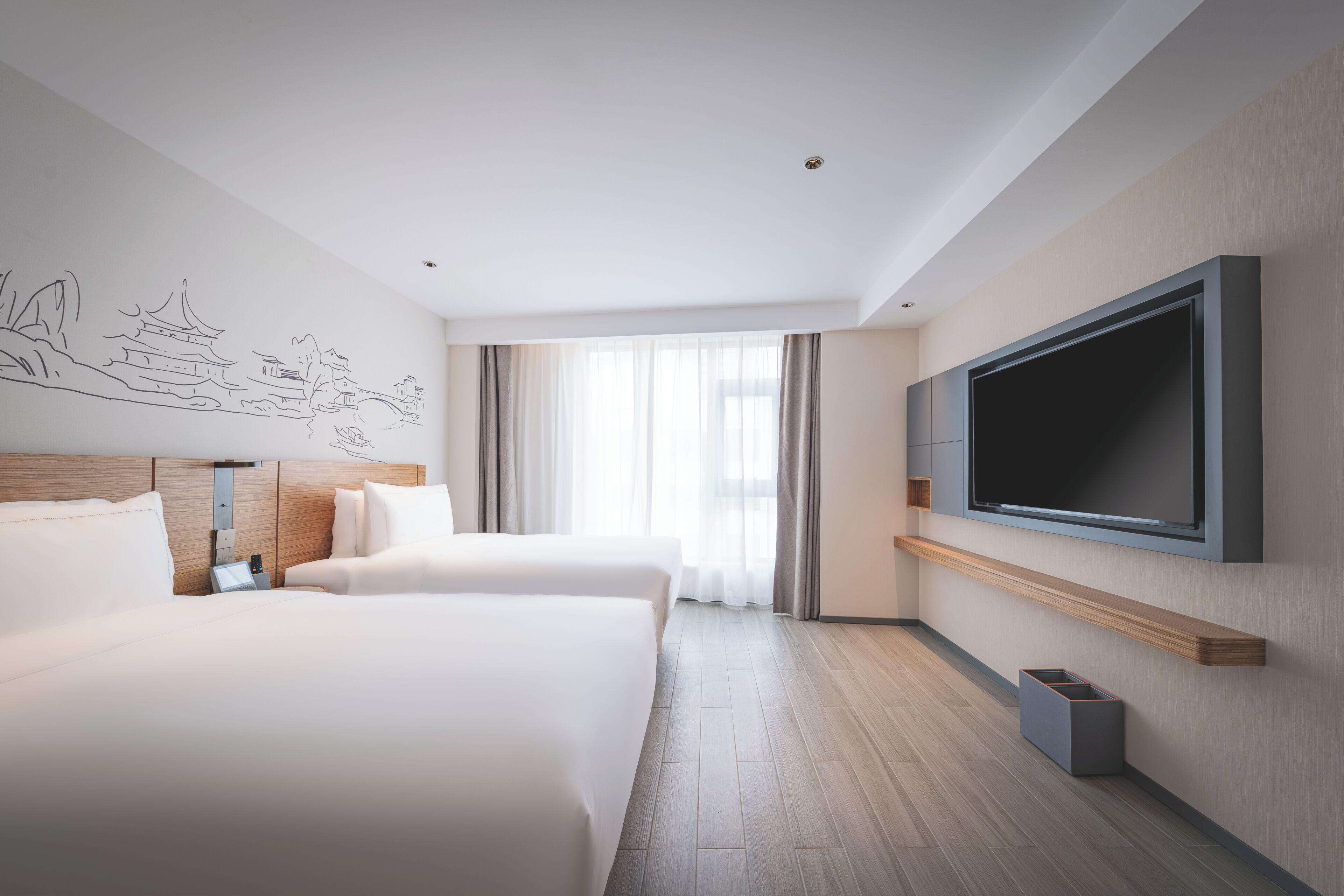 Habitación de hotel con dos camas, un televisor de pantalla plana grande y un mural en la pared.