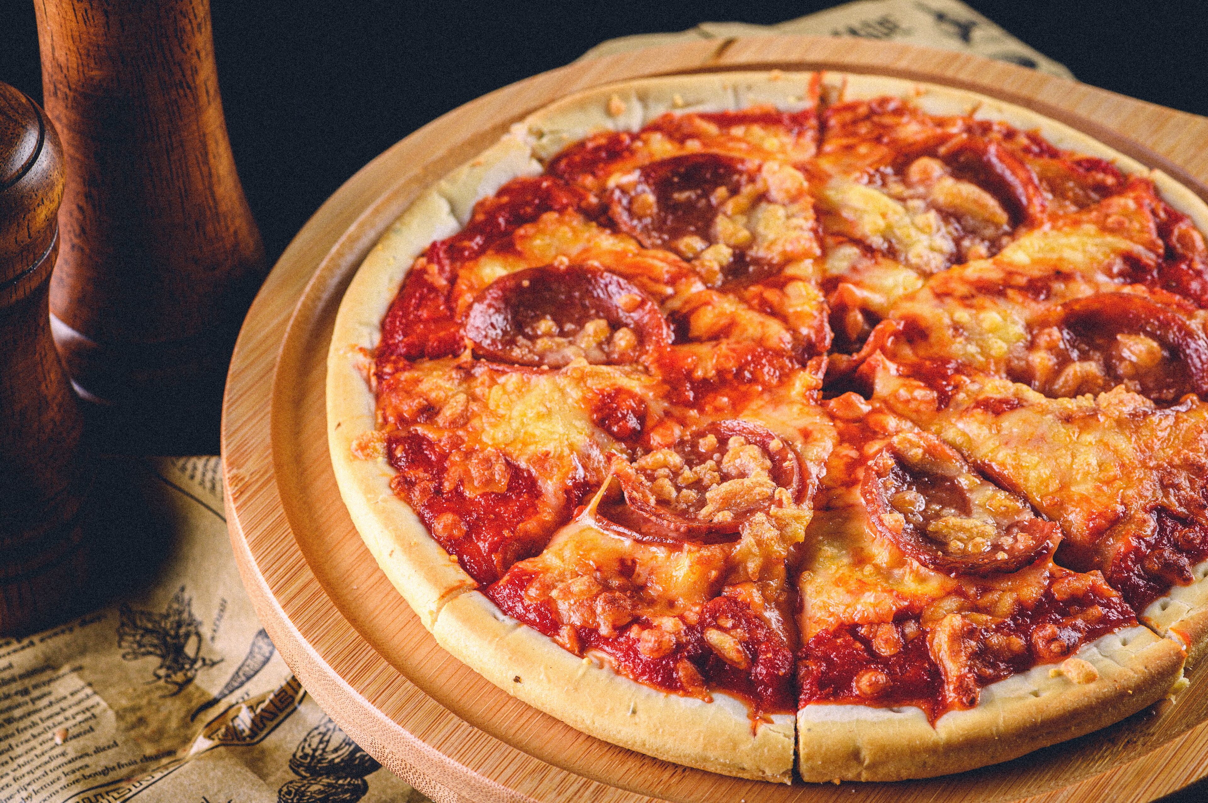 A pizza on a wooden board.