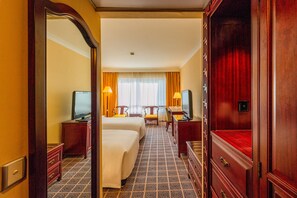 Habitación Deluxe | Edredón, caja de seguridad en la habitación y escritorio