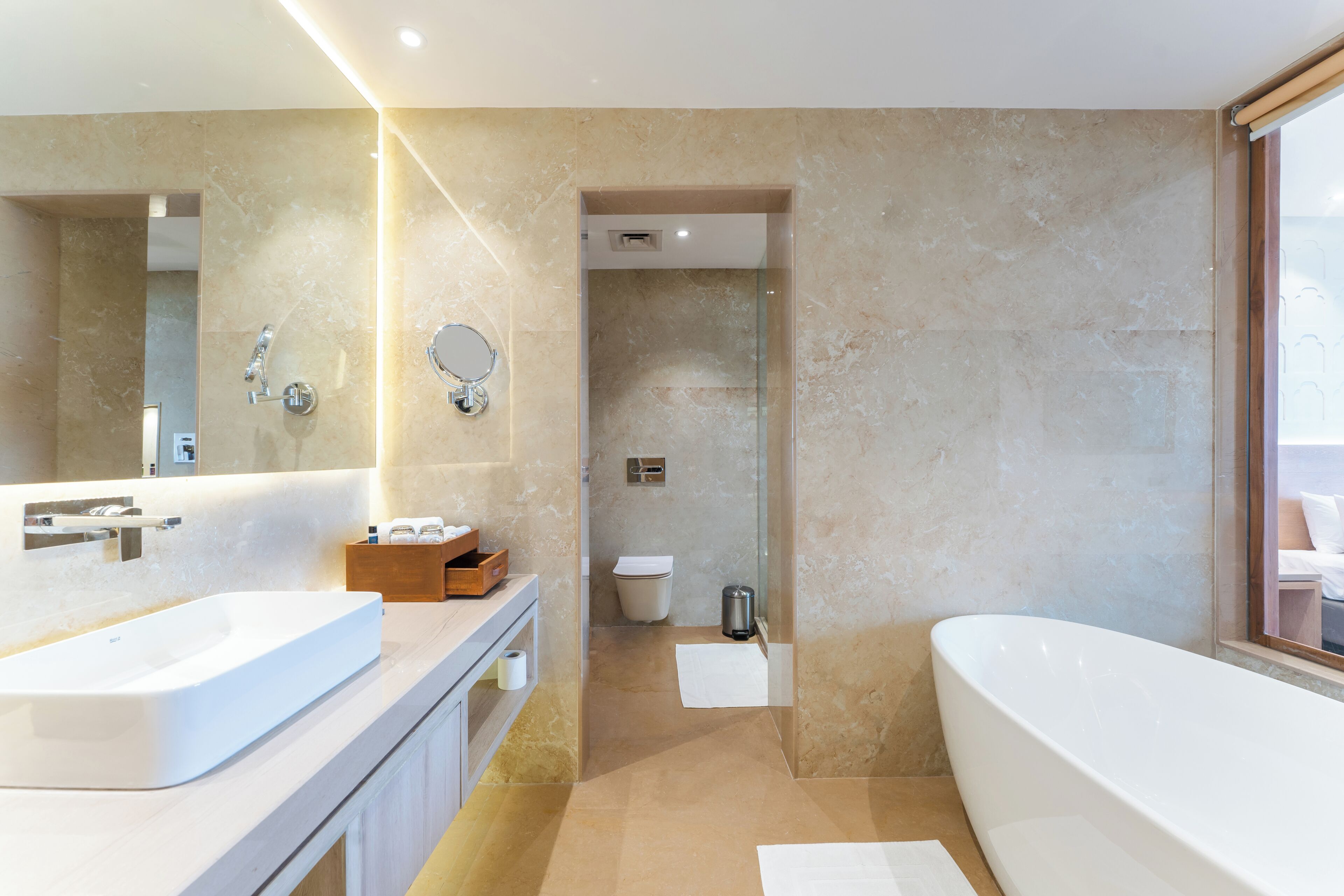 Un bagno moderno con una vasca da bagno ampia, un mobile bagno doppio, uno specchio e uno spazio doccia.